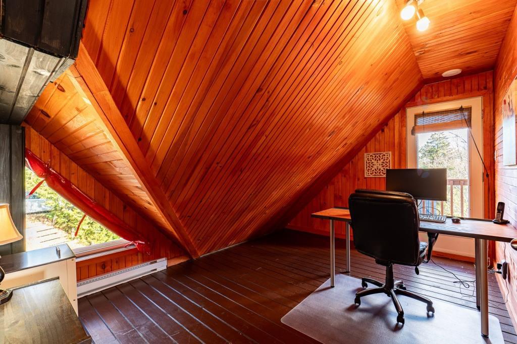 Vendu meublé! Superbe chalet en bois rond perché au-dessus d'un lac