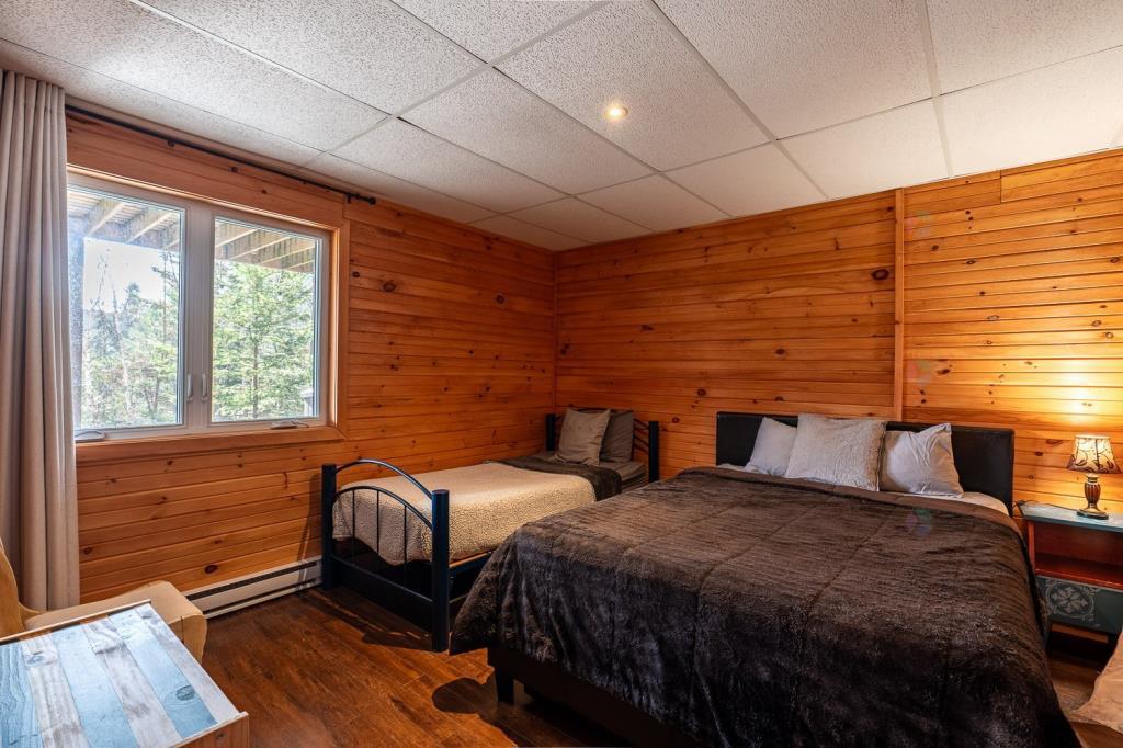 Vendu meublé! Superbe chalet en bois rond perché au-dessus d'un lac
