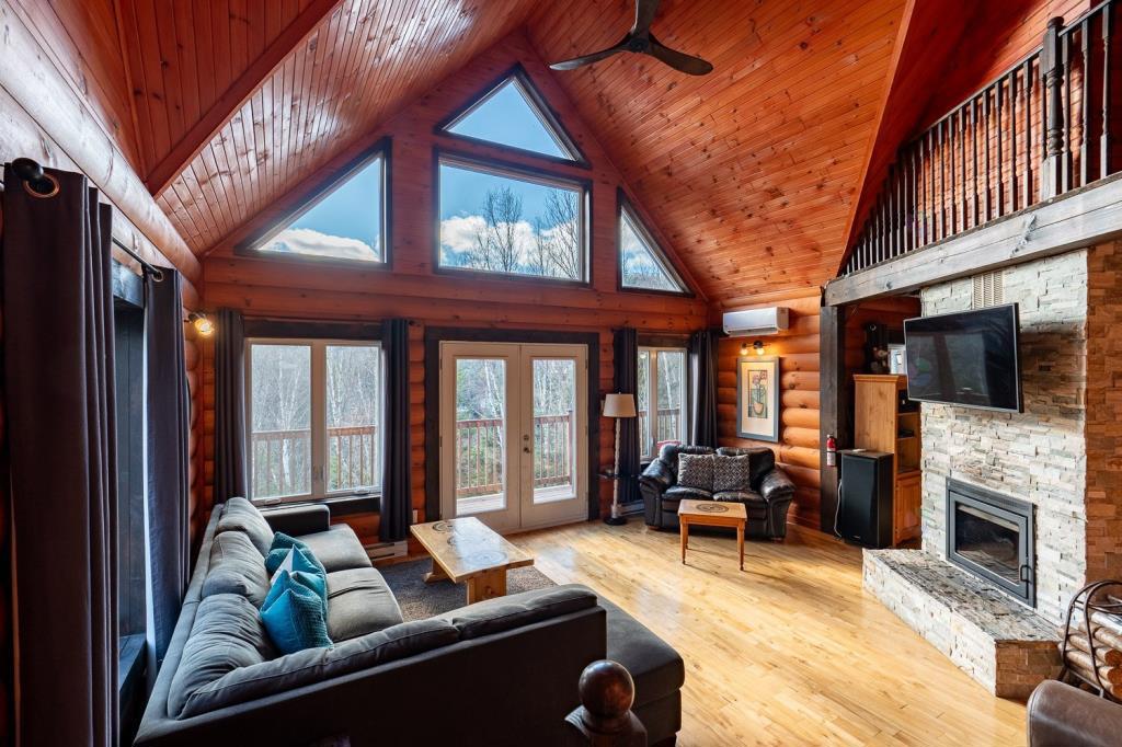 Vendu meublé! Superbe chalet en bois rond perché au-dessus d'un lac