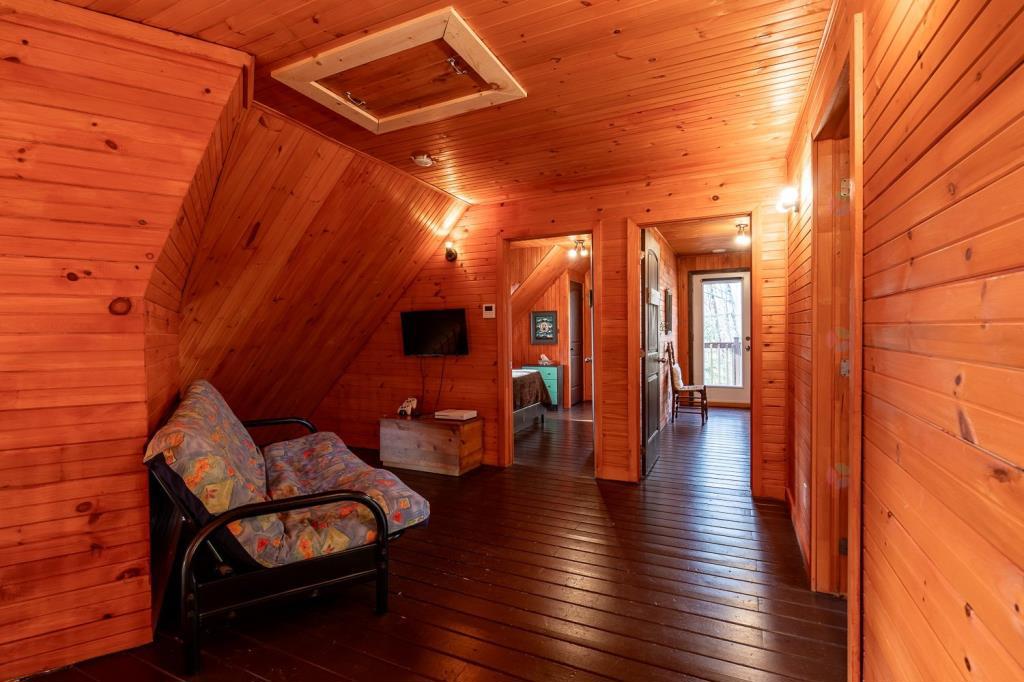 Vendu meublé! Superbe chalet en bois rond perché au-dessus d'un lac