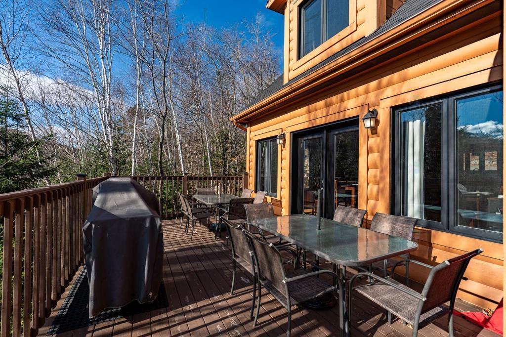 Vendu meublé! Superbe chalet en bois rond perché au-dessus d'un lac