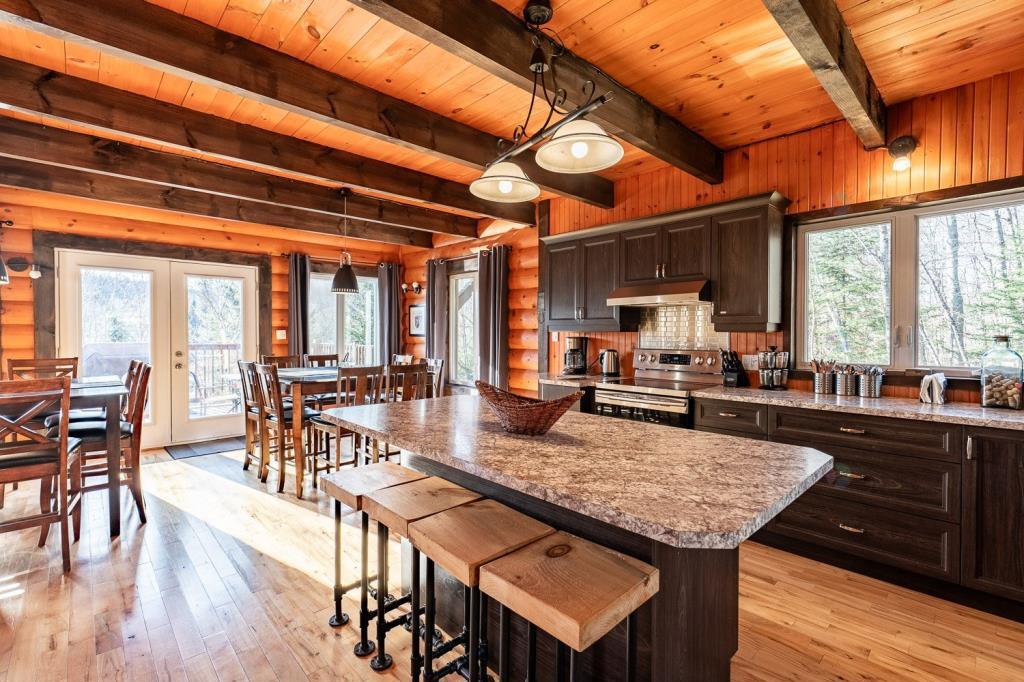 Vendu meublé! Superbe chalet en bois rond perché au-dessus d'un lac