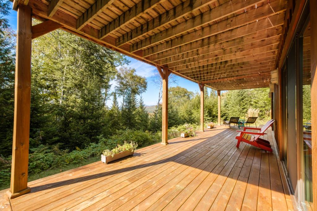 Vendu meublé! Superbe cottage en bois rond niché sur un site digne d'une carte postale