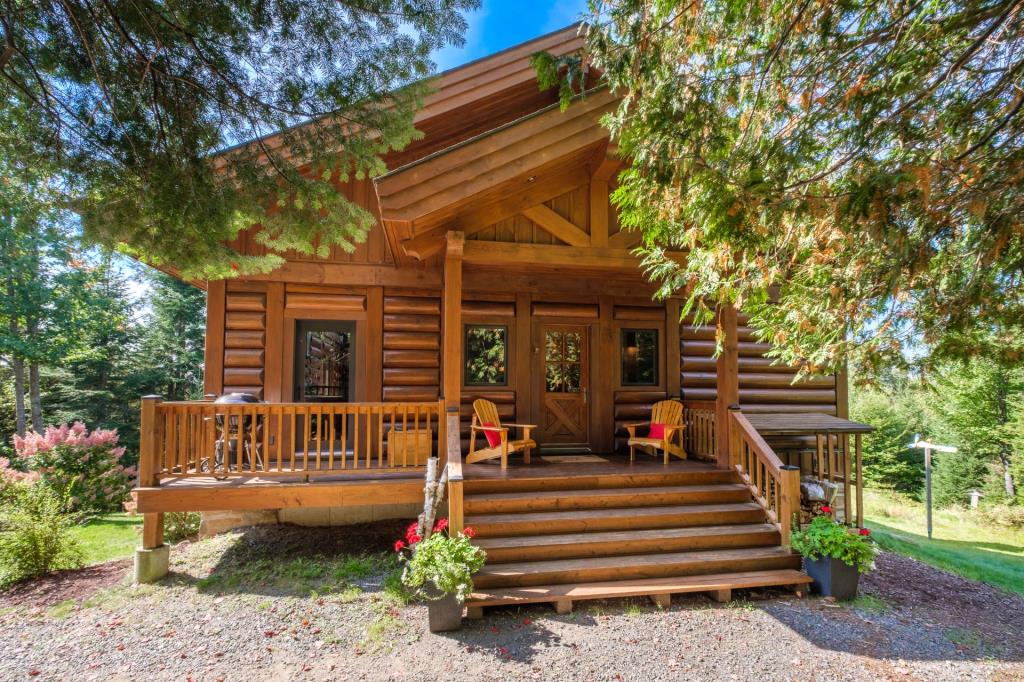 Vendu meublé! Superbe cottage en bois rond niché sur un site digne d'une carte postale