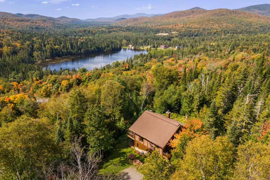 Vendu meublé! Superbe cottage en bois rond niché sur un site digne d'une carte postale