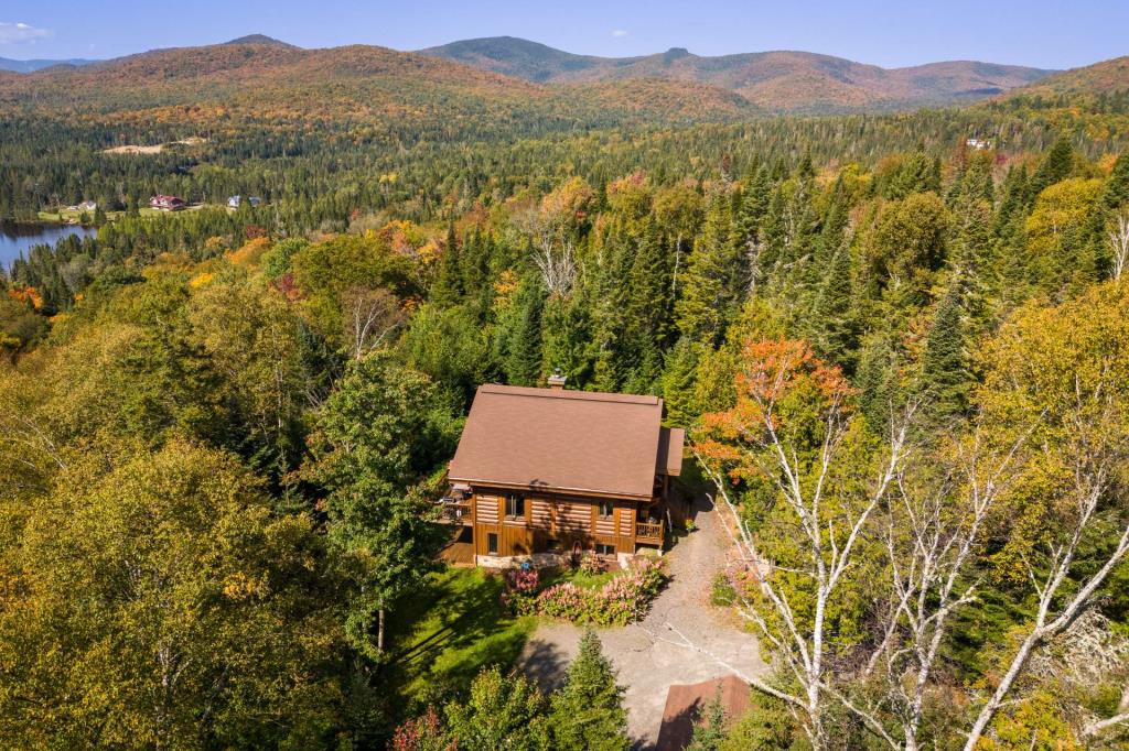 Vendu meublé! Superbe cottage en bois rond niché sur un site digne d'une carte postale