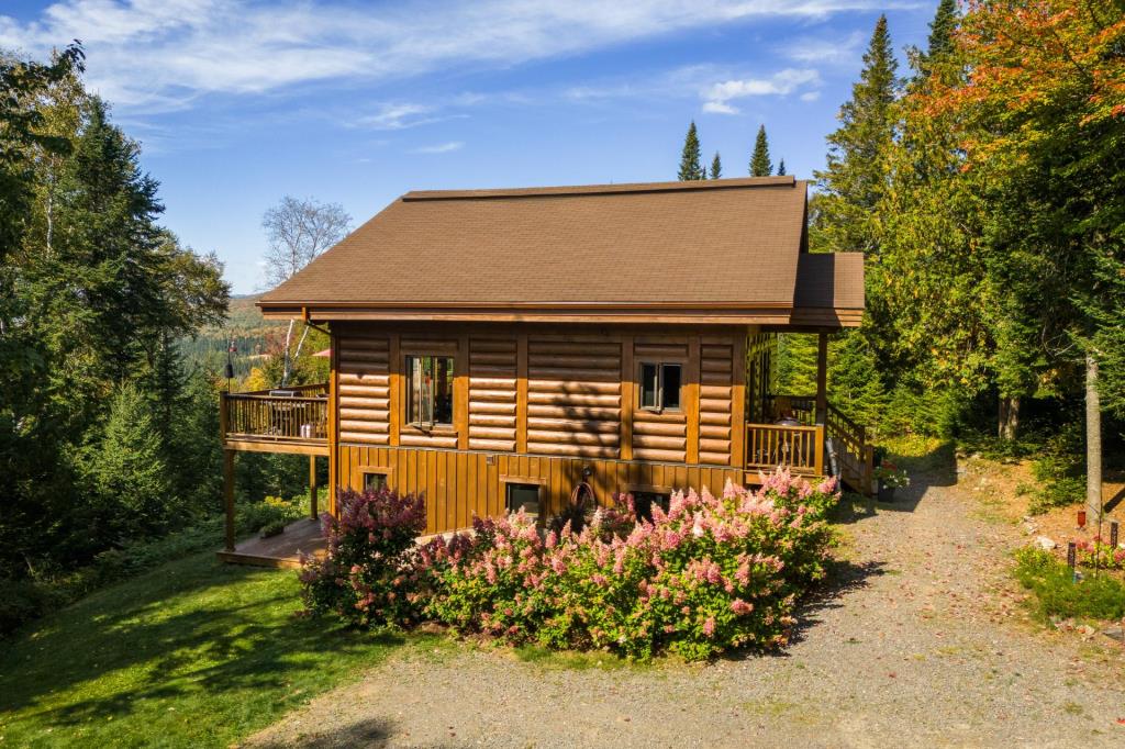 Vendu meublé! Superbe cottage en bois rond niché sur un site digne d'une carte postale