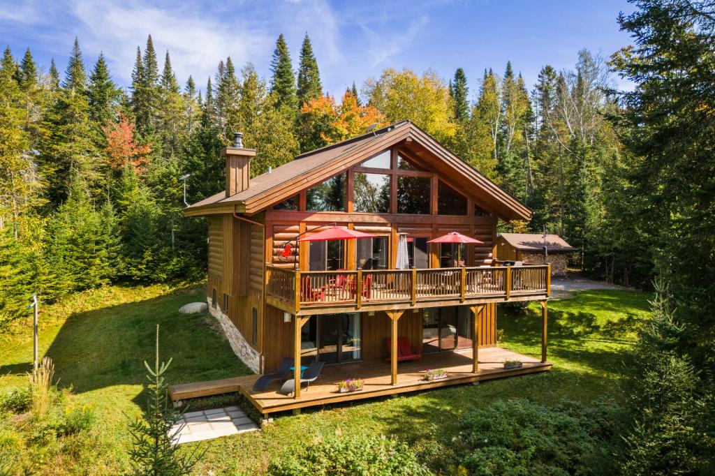 Vendu meublé! Superbe cottage en bois rond niché sur un site digne d'une carte postale