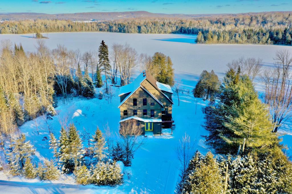 Splendide refuge blotti au creux de la forêt sur la rive d'un lac