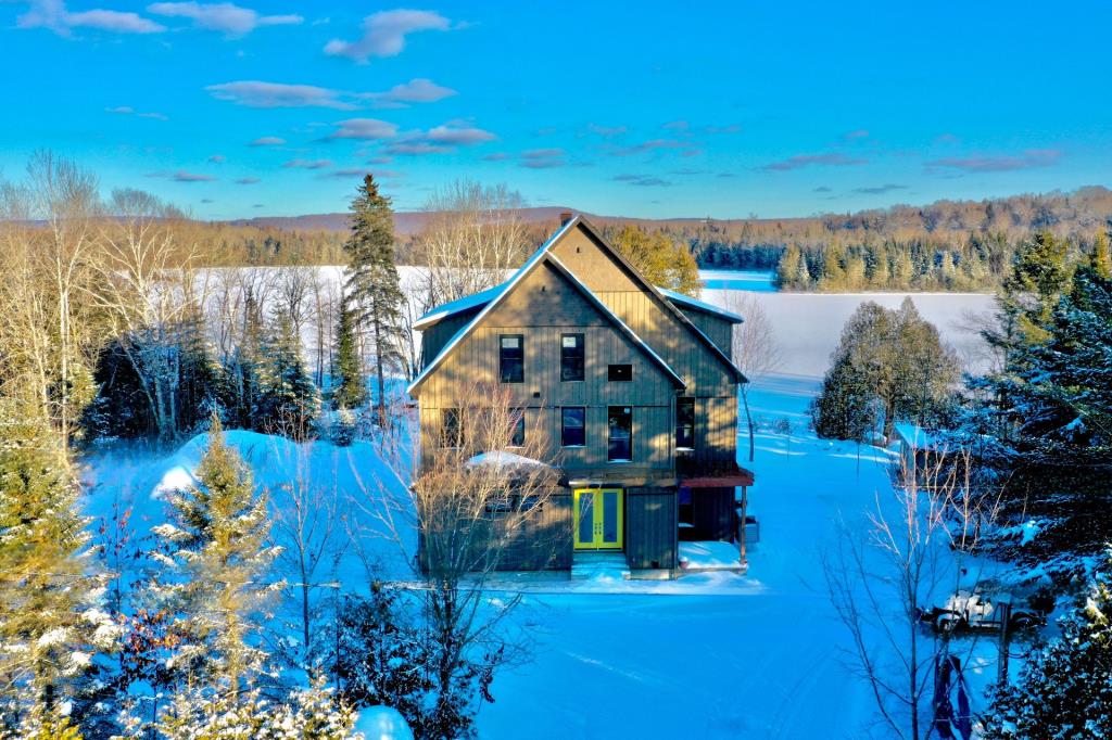 Splendide refuge blotti au creux de la forêt sur la rive d'un lac
