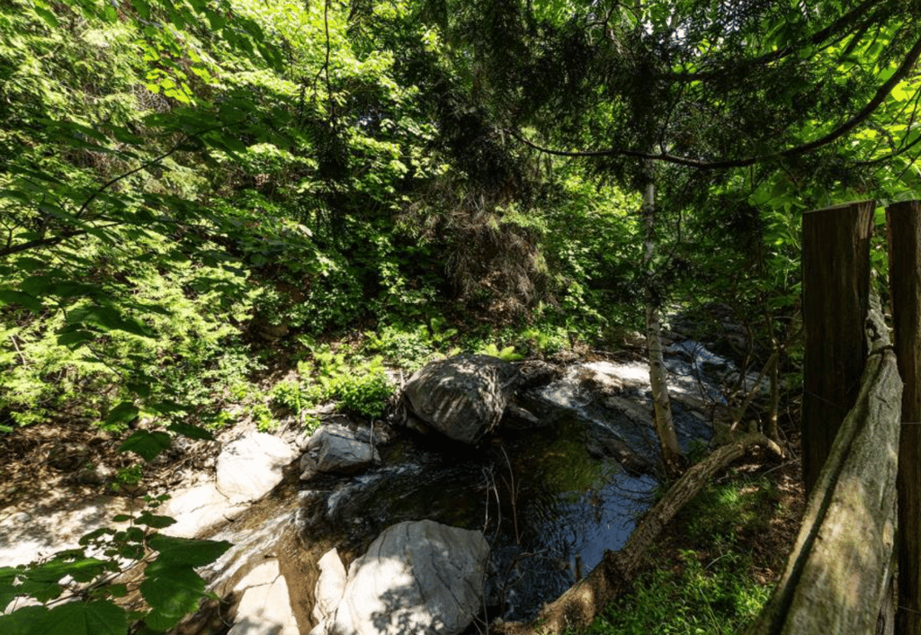 Belle d'autrefois avec petite cabane à sucre au pied d'une chute