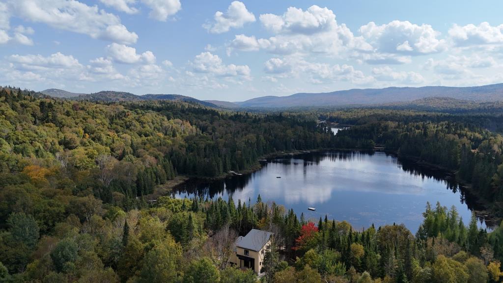 Séduisante propriété surplombant les eaux calmes d'un lac au milieu de la forêt