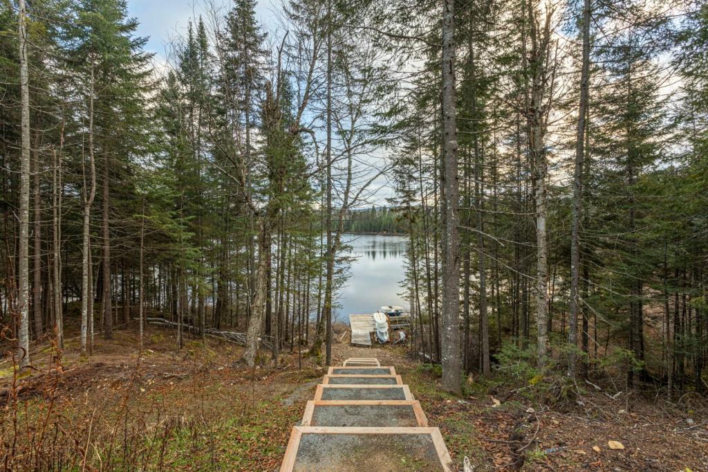 Séduisante propriété surplombant les eaux calmes d'un lac au milieu de la forêt