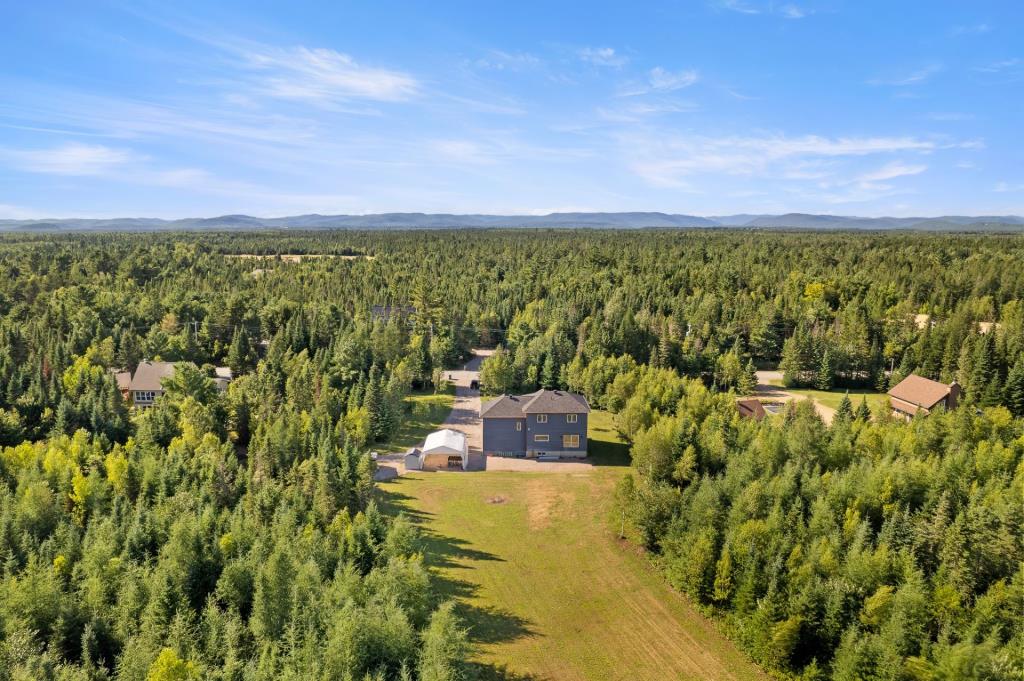 Construction moderne entourée de forêt sur un impressionnant terrain de 162 000 pi²