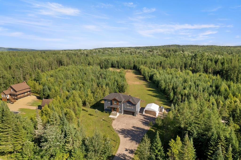 Construction moderne entourée de forêt sur un impressionnant terrain de 162 000 pi²