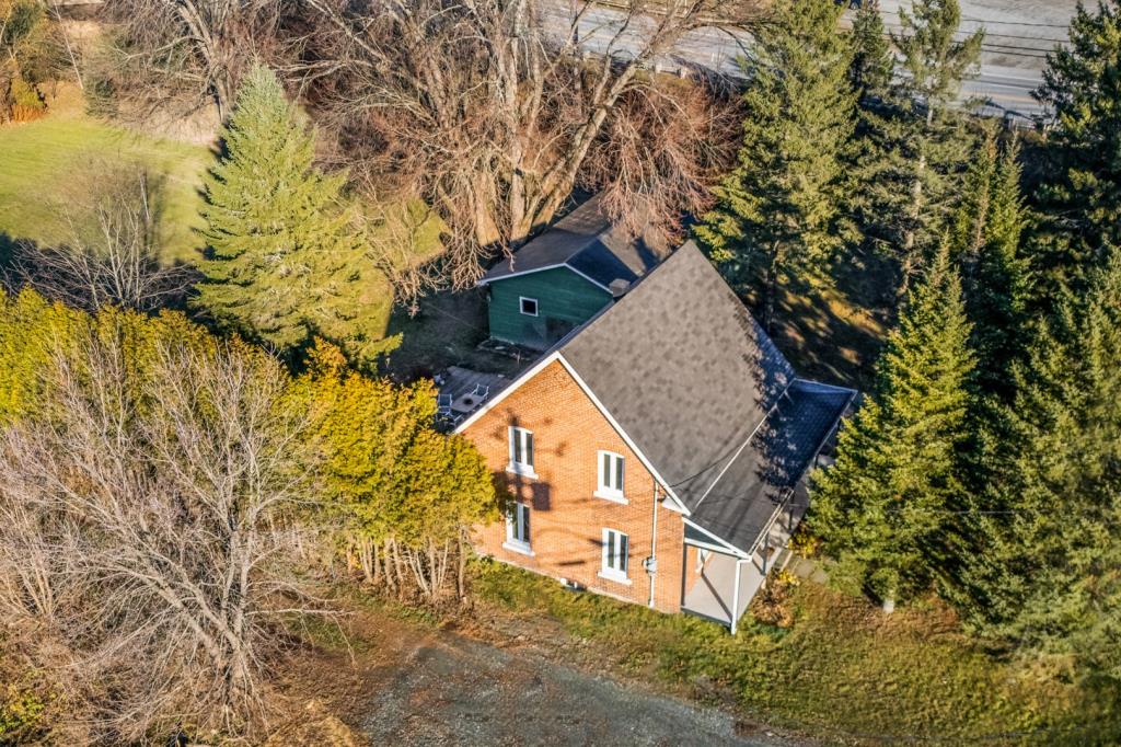 Cottage au cachet chaleureux entouré d'arbres matures sur un vaste terrain riverain