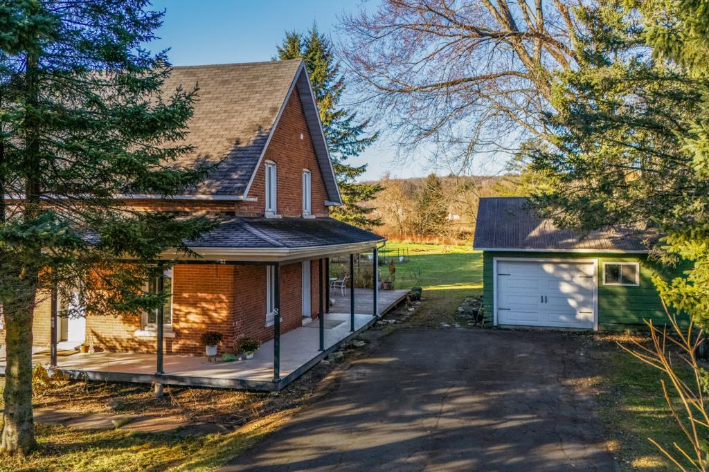 Cottage au cachet chaleureux entouré d'arbres matures sur un vaste terrain riverain