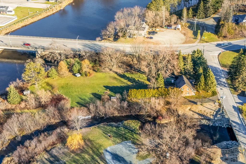 Cottage au cachet chaleureux entouré d'arbres matures sur un vaste terrain riverain