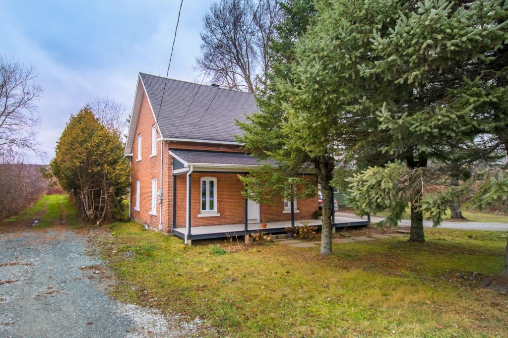 Cottage au cachet chaleureux entouré d'arbres matures sur un vaste terrain riverain