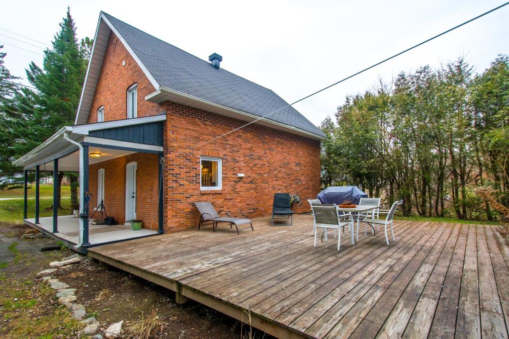 Cottage au cachet chaleureux entouré d'arbres matures sur un vaste terrain riverain