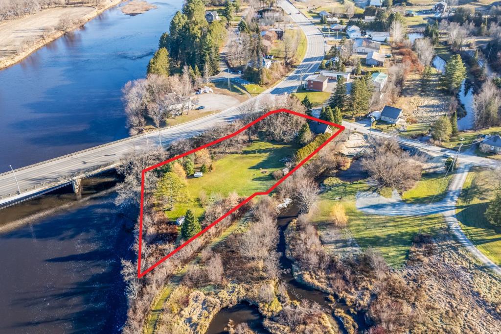 Cottage au cachet chaleureux entouré d'arbres matures sur un vaste terrain riverain