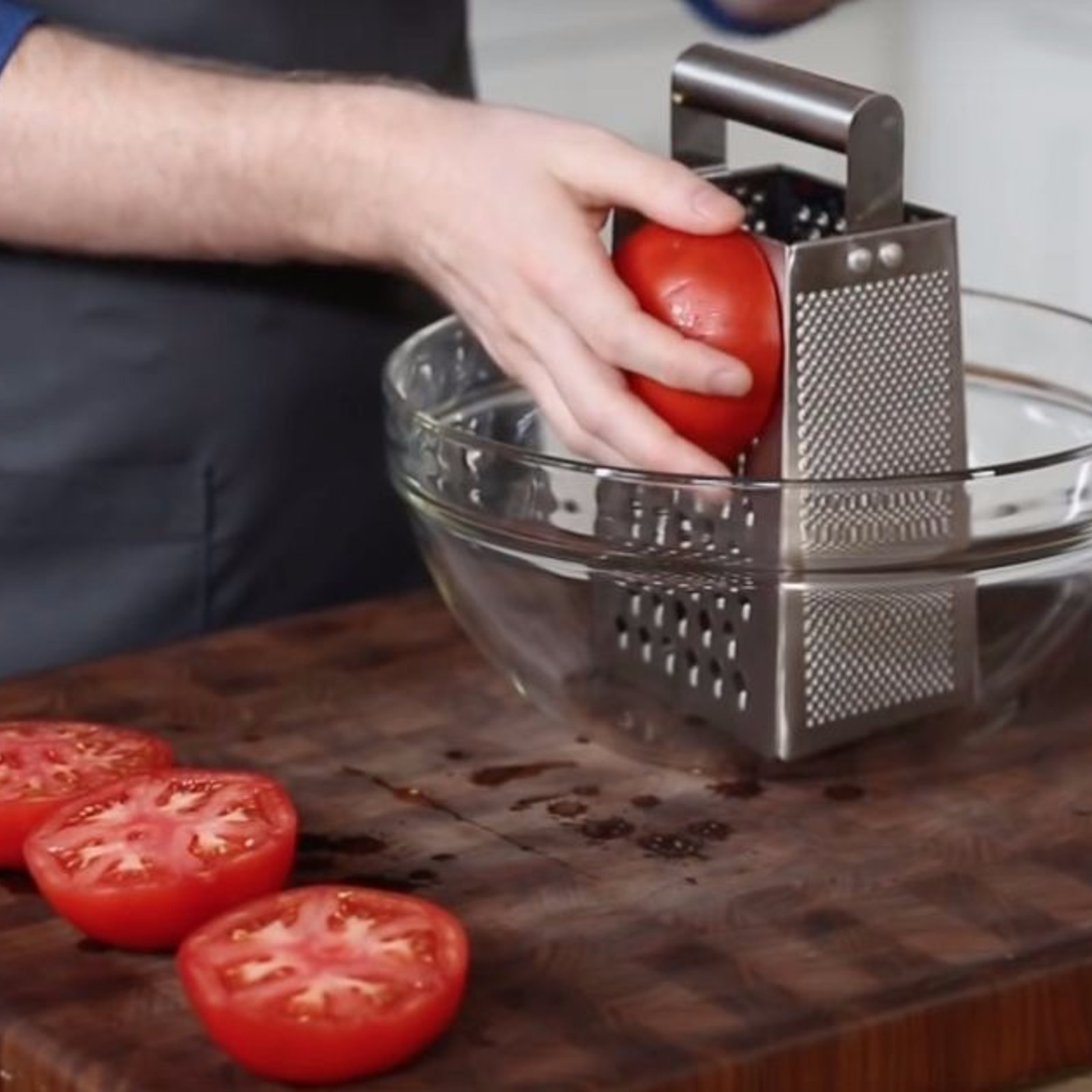 Il réduit une tomate en purée avec une râpe à fromage: regardez bien sa main quand il finit! 