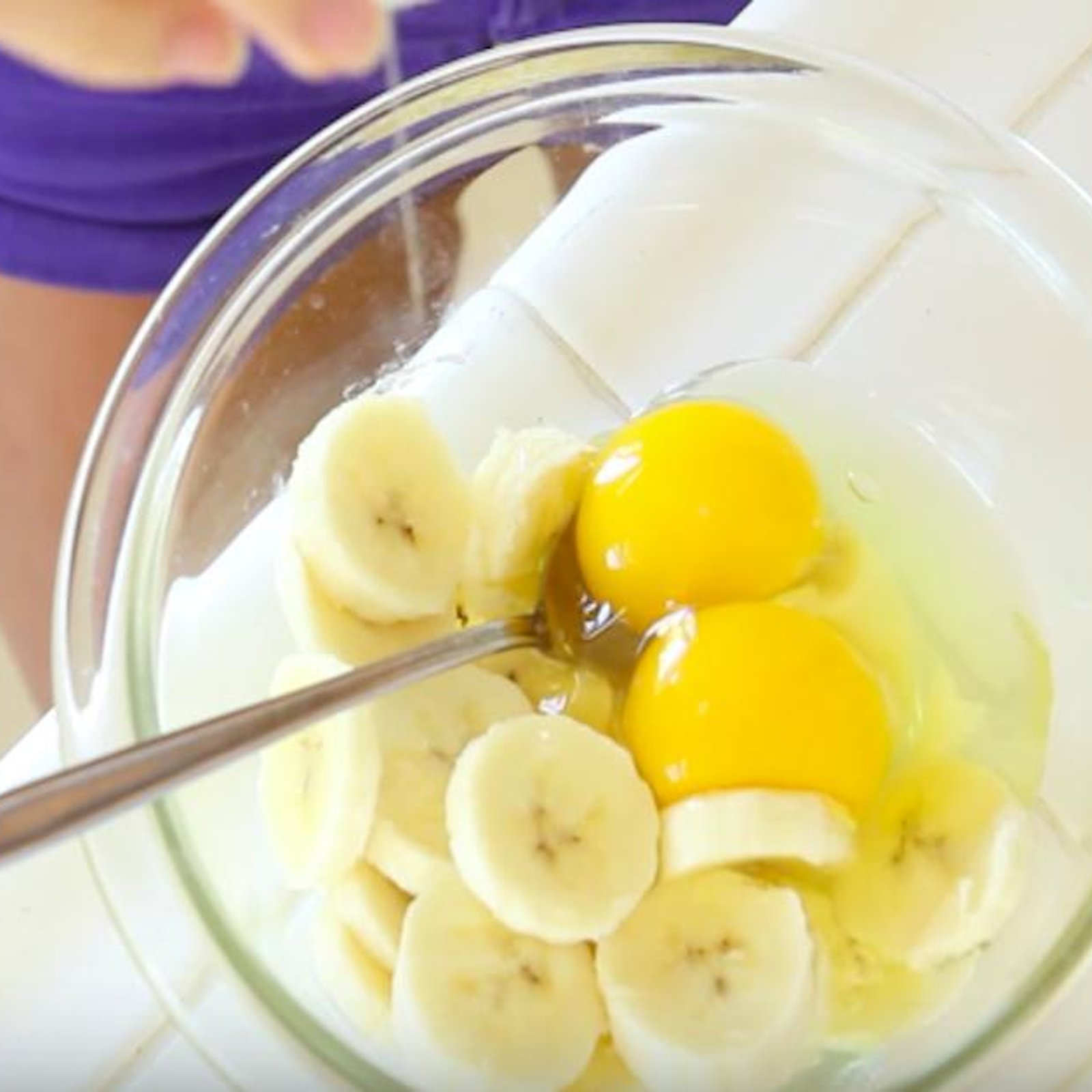 Dans un bol, elle mélange des oeufs et des morceaux de bananes. Elle obtient un déjeuner nutritif à souhait!