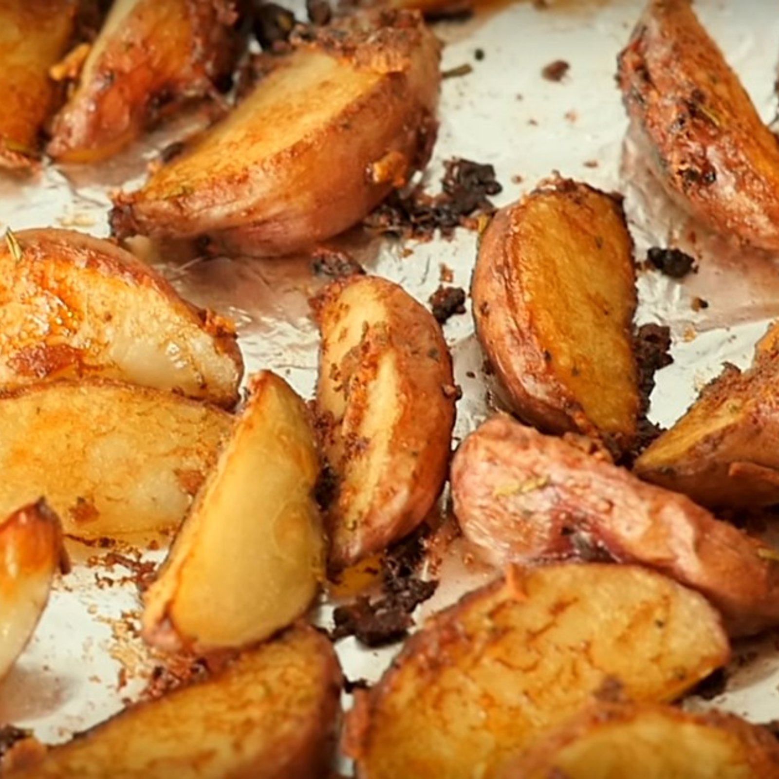 Elle place les quartiers de pommes de terre sur une plaque et les saupoudre d'un ingrédient qui fait toute la différence