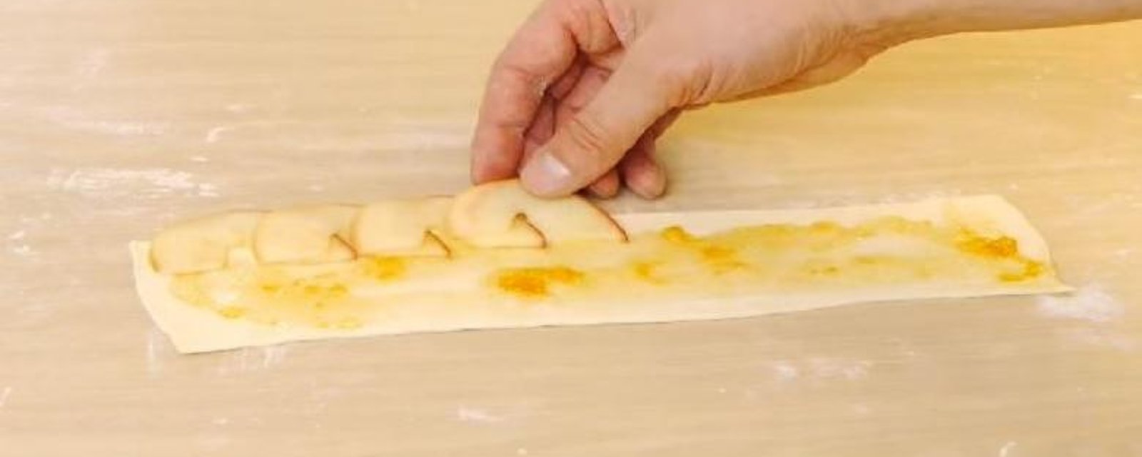 Il étale des tranches de pommes sur un rectangle de pâte... Cette astuce vous permettra de faire de magnifiques feuilletés