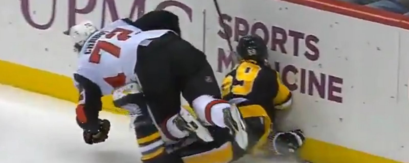 Jake Guentzel goes head first into the boards after scoring a goal.