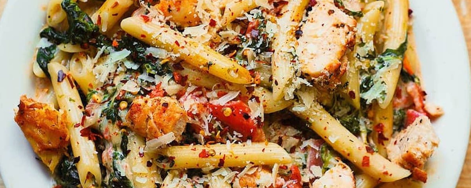 Recette réconfort: pâtes au poulet et bacon avec épinards et tomates dans une sauce crémeuse