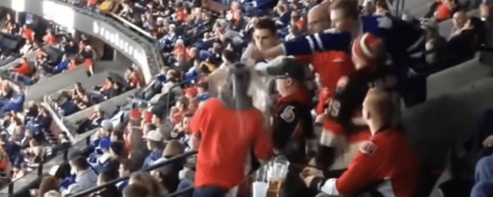 Un partisan des Leafs vide sa bière sur la tête d'un fan des Sens