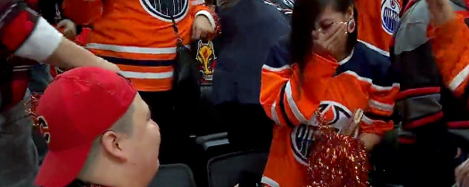 Flames fan proposes to Oilers fan in the crowd at Game 4