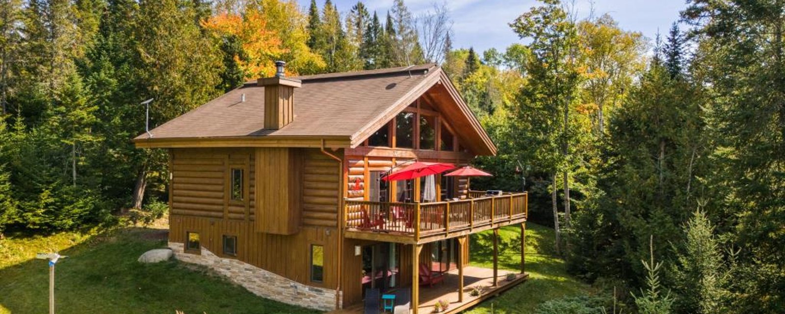 Vendu meublé! Superbe cottage en bois rond niché sur un site digne d'une carte postale