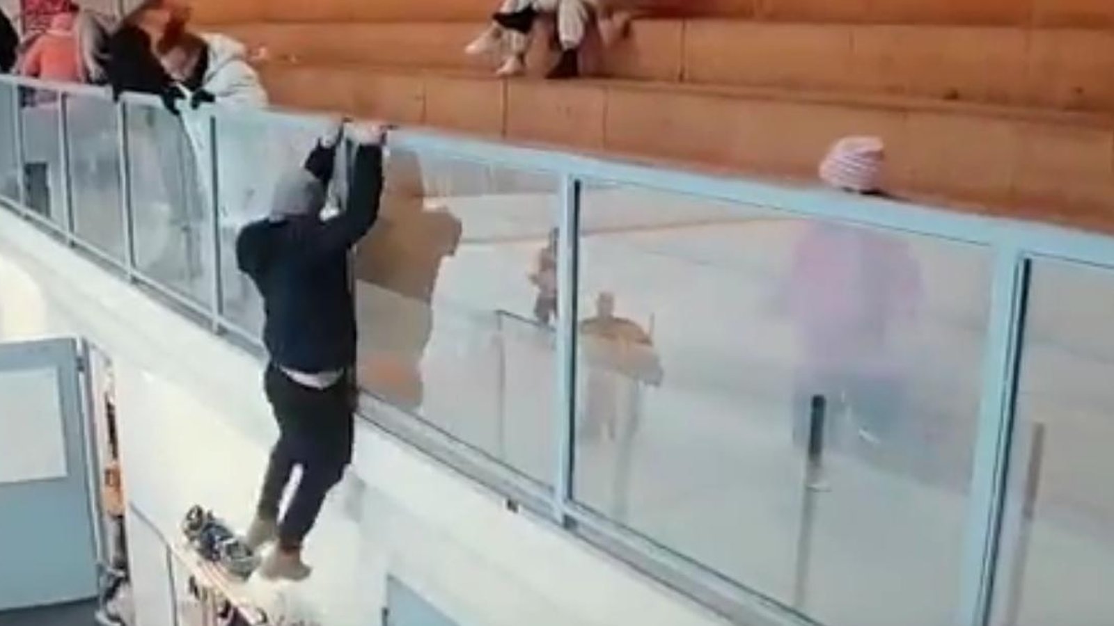 Crazed hockey fan jumps over the glass to attack a player.