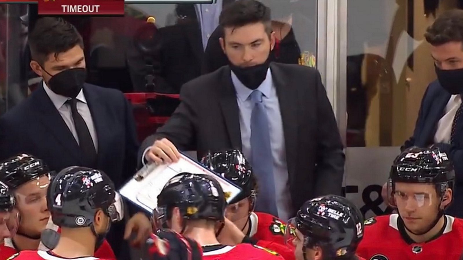 Blackhawks head coach Jeremy Colliton hands over his whiteboard to the players.