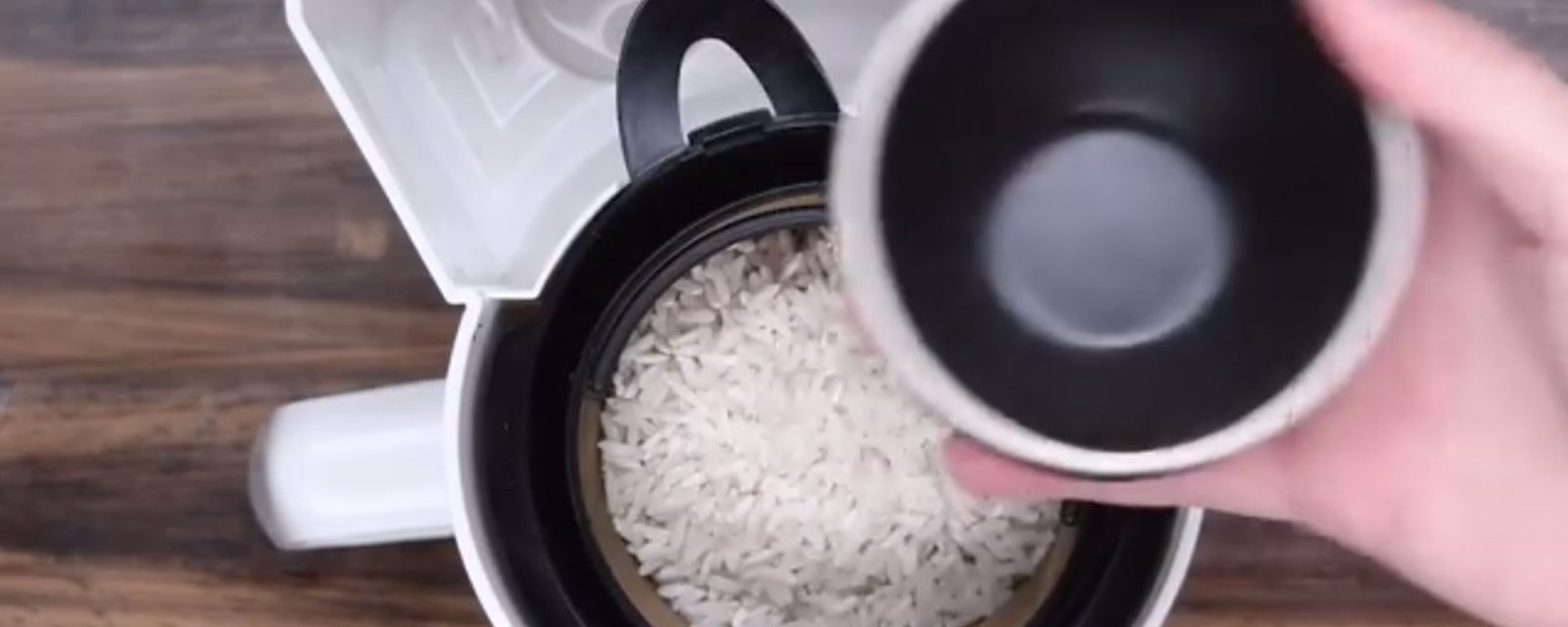 Elle met du riz dans sa cafetière et remplit le réservoir d'eau