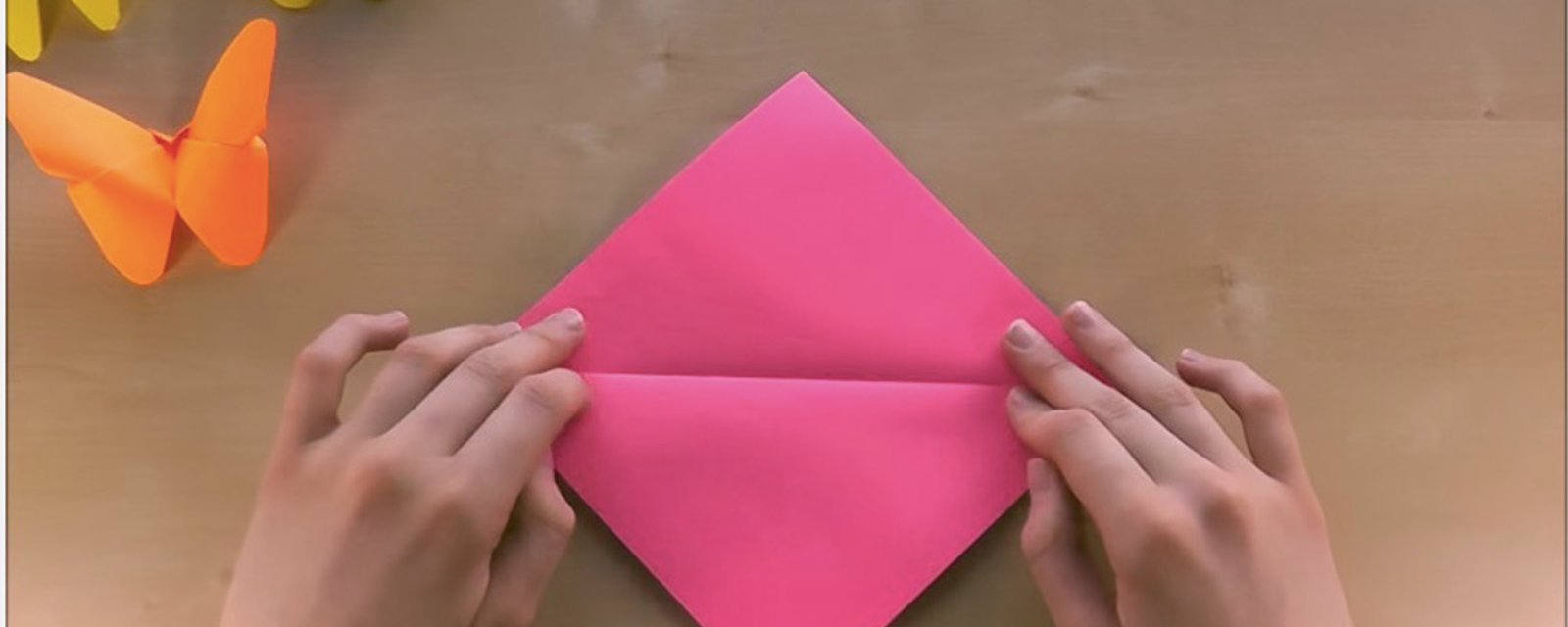 Elle coupe un carré dans un papier très coloré et en quelques plis seulement, elle réalise le plus magnifique des papillons! 