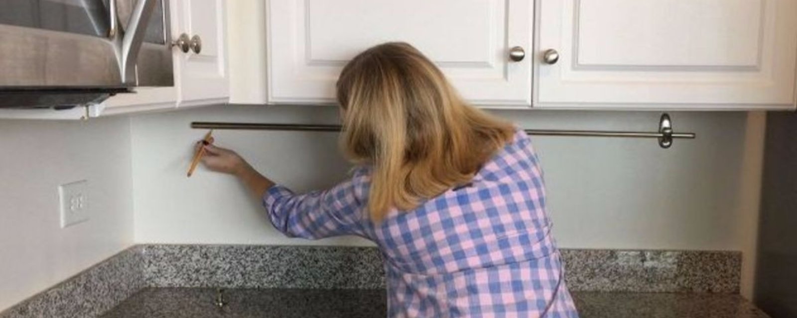En installant une tringle à rideaux sur son mur de cuisine, elle ajoute un rangement auquel on ne penserait pas!