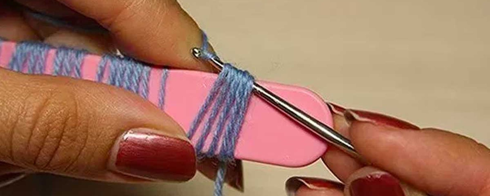 Elle enroule sa laine autour d'une lime à ongles et nous montre une technique de crochet vraiment simple