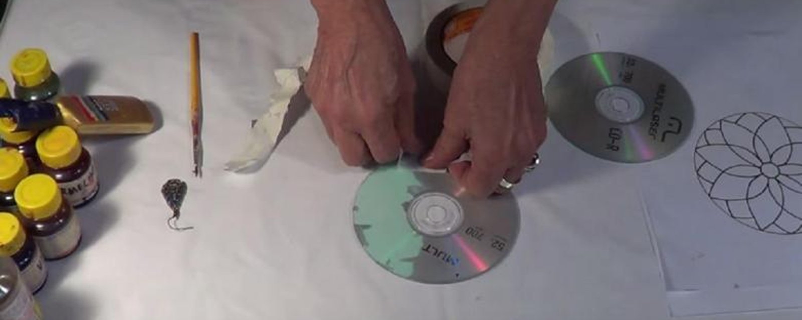 En retirant le papier sur un CD, elle réalise un mandala tout en couleur! 