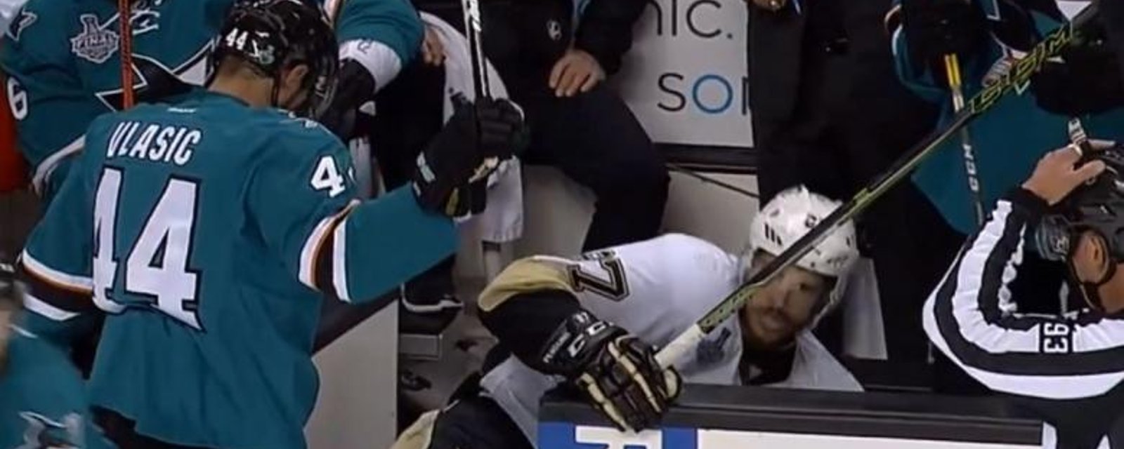 Vlasic shoves Crosby in to the Sharks bench.