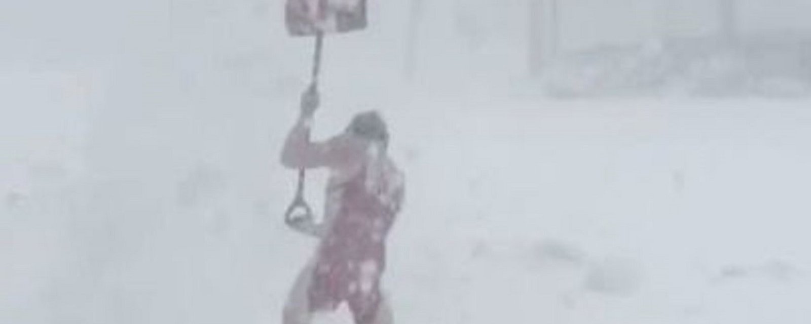 High school wrestler shovels snow in nothing but his wrestling gear.