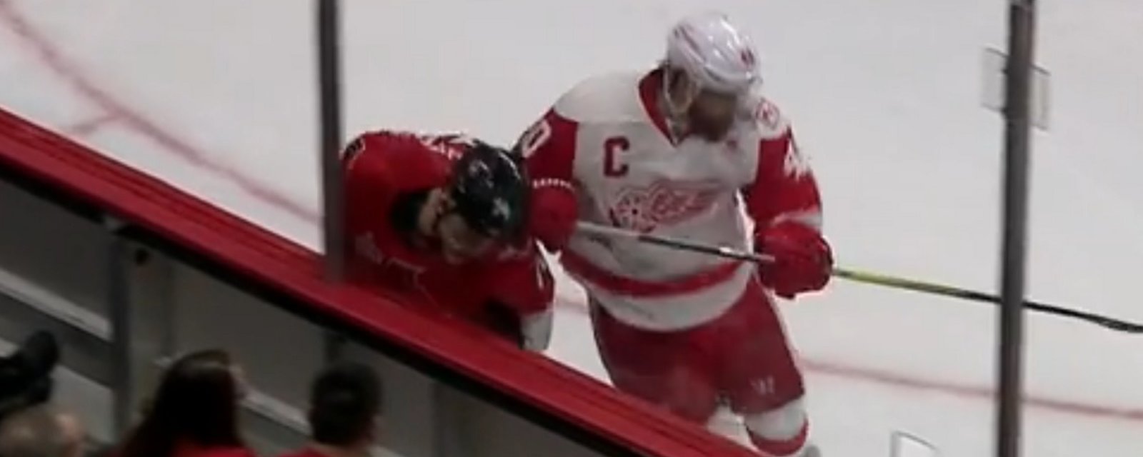 Wings captain Henrik Zetterberg delivers an out-of-character hit from behind.