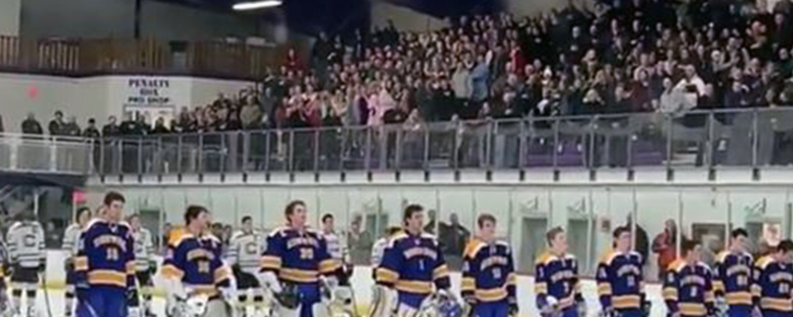 High School hockey fans step up to sing National Anthem after arena PA system malfunctions.
