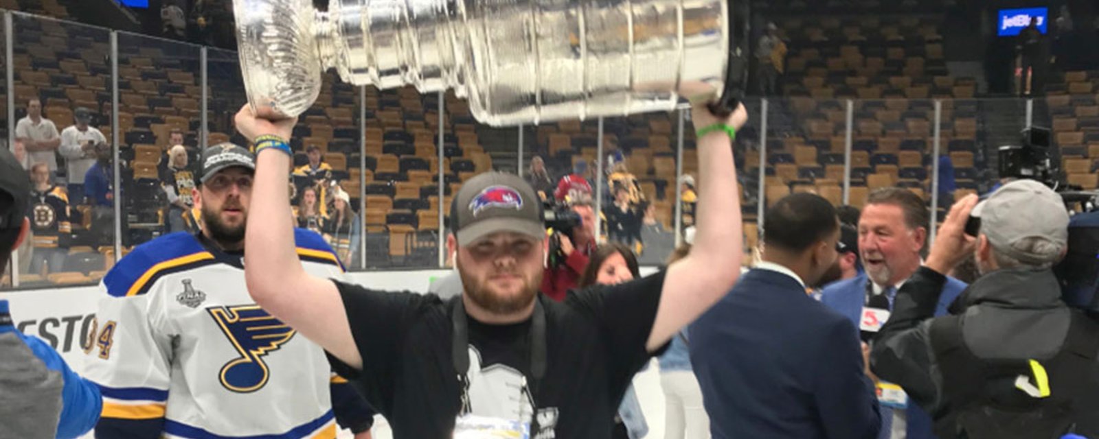 Boston fan sneaks onto the ice after Game 7 and hoists the Cup with the Blues