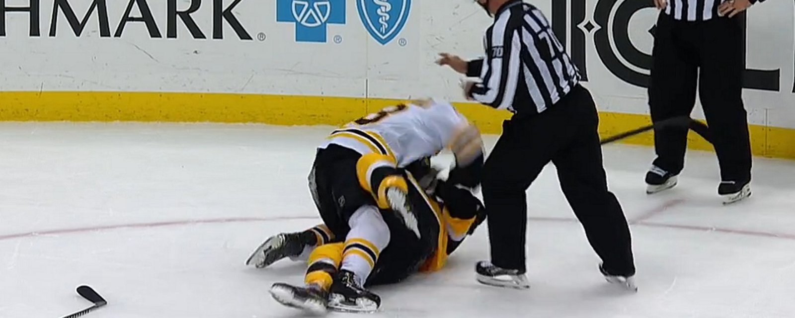 Brad Marchand and Kris Letang rough each other up behind the play.