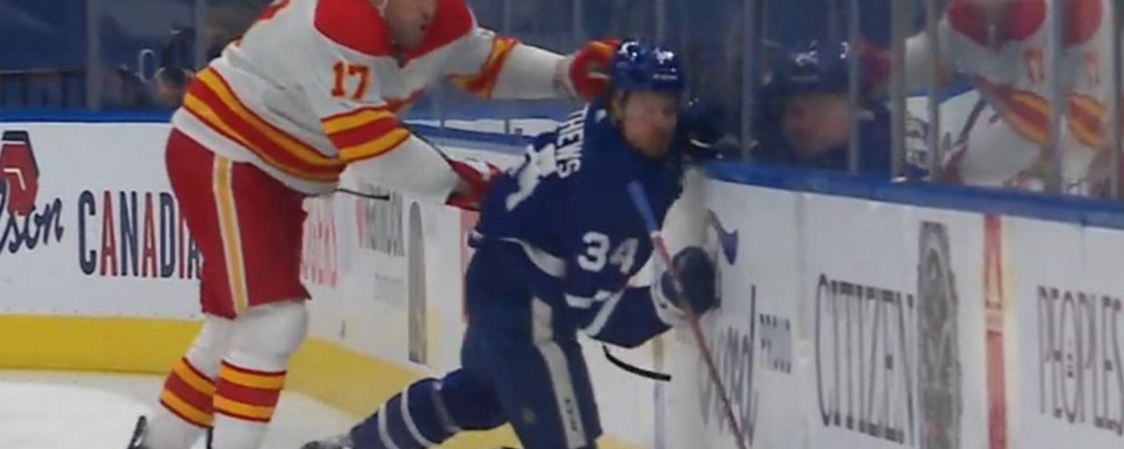 Milan Lucic sends Auston Matthews into the boards with a hit from behind.