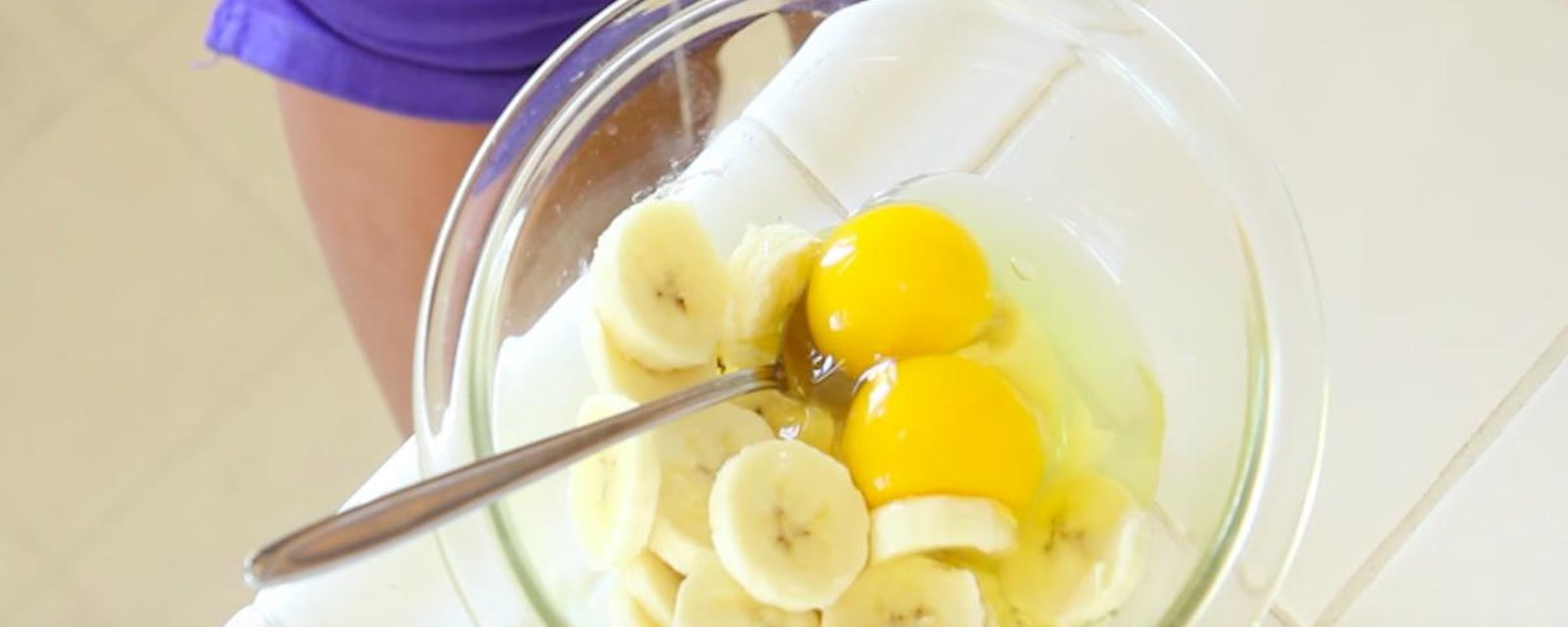 Dans un bol, elle mélange des oeufs et des morceaux de bananes. Elle obtient un déjeuner nutritif à souhait!