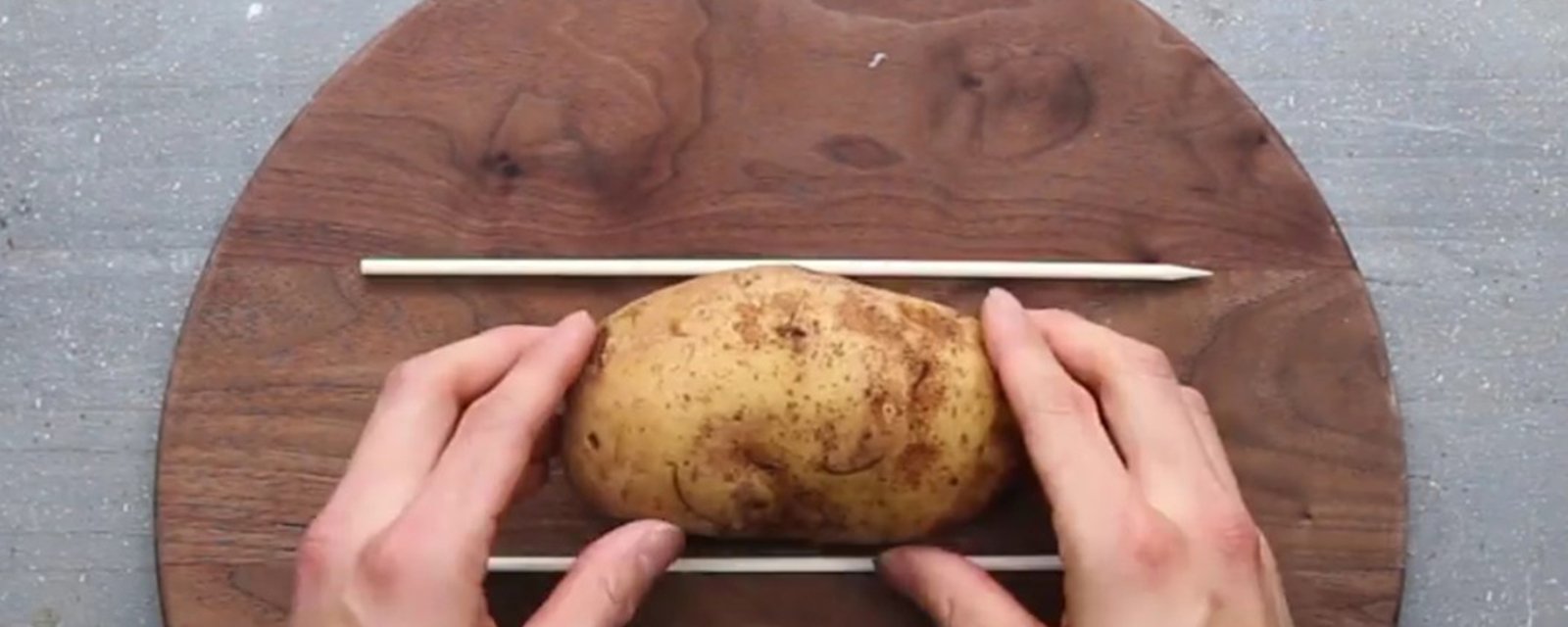 Il place une pomme de terre entre 2 baguettes afin de nous montrer une toute nouvelle façon d'apprêter les pommes de terre